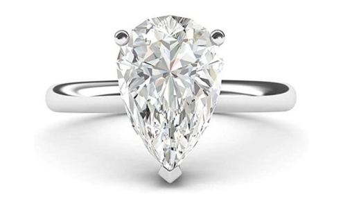 A close-up of a simple yet elegant De Beers Forevermark engagement ring with a pear cut centre stone, available at Nash Jewellers.