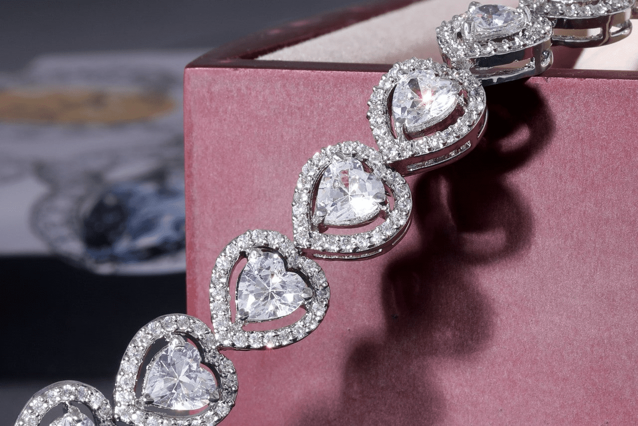 a diamond heart necklace draped over a purple gift box