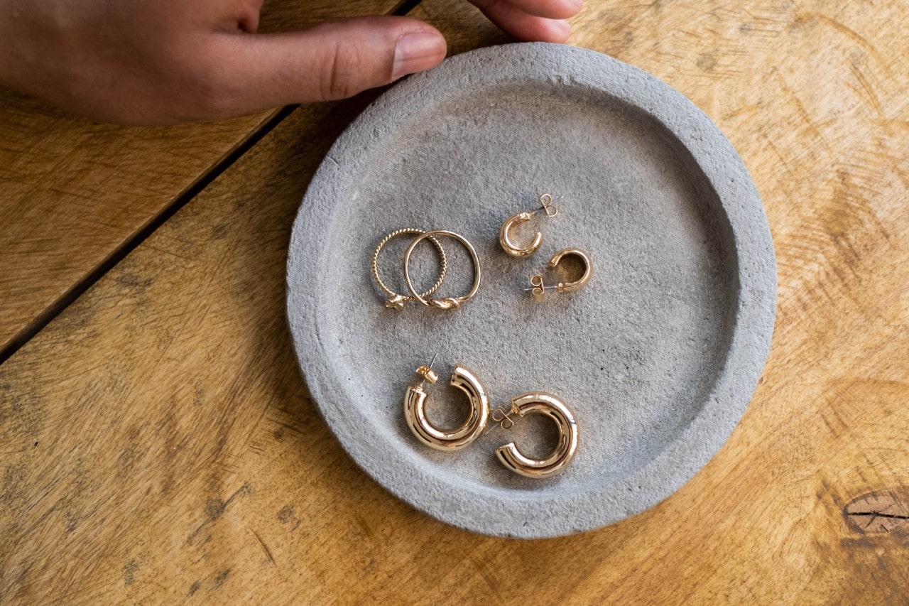everal yellow gold hoops on top of the grey plate on a wooden surface.