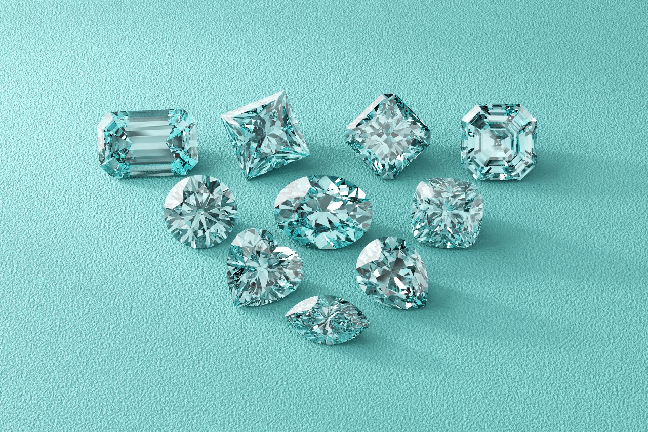 Ten sparkling aquamarine gemstones in various shapes arranged on a textured teal surface.