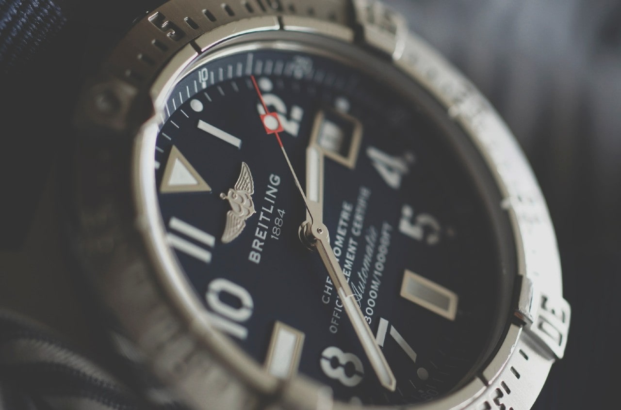 A close up Breitling watch with deep black dial and arab numerals.