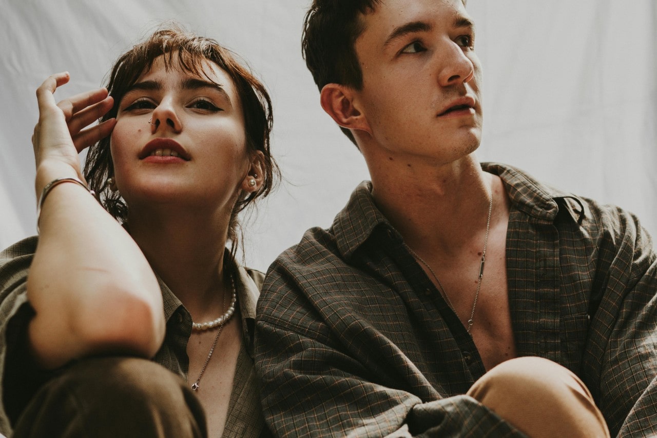 a couple in coordinating outfits and chain necklaces