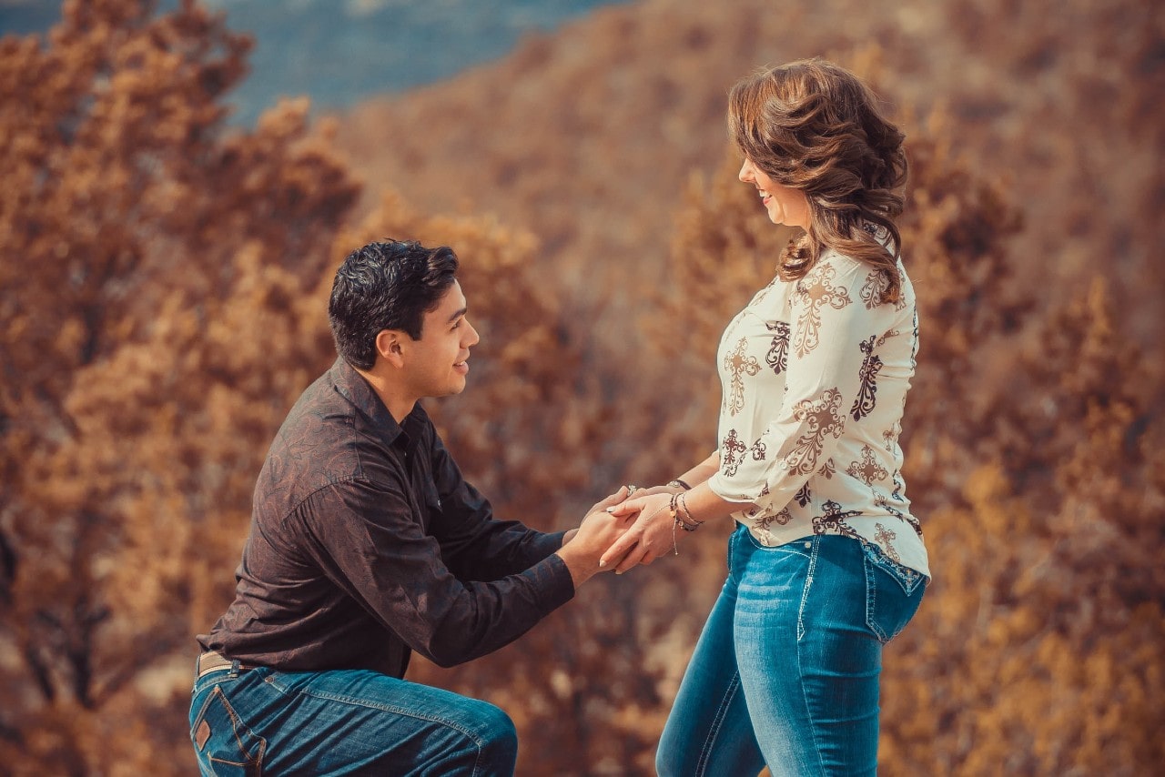 A man proposes to his beloved during a fall hike. A man proposes to his beloved during a fall hike.