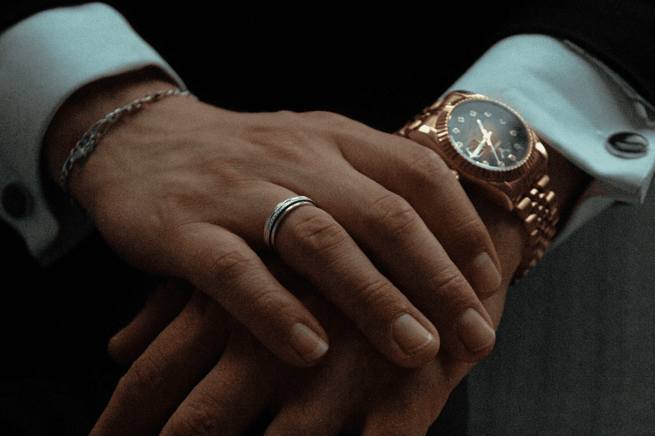 man’s hands clasped and wearing a luxury watch and jewellery man’s hands clasped and wearing a luxury watch and jewellery