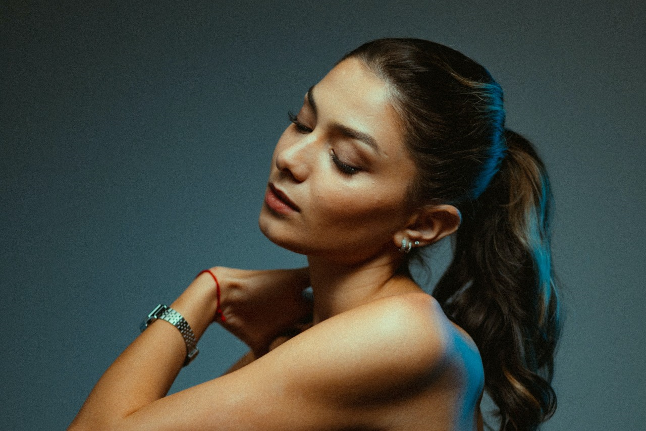 woman wearing a luxury watch and earrings