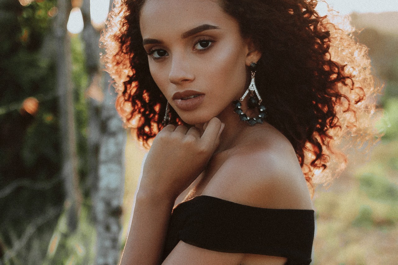 a woman walking looks back to show off her diamond and gemstone drop earrings.