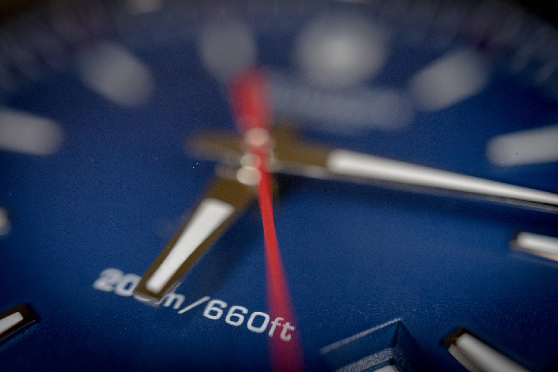 A close-up of a dark blue watch dial with black and white hands.