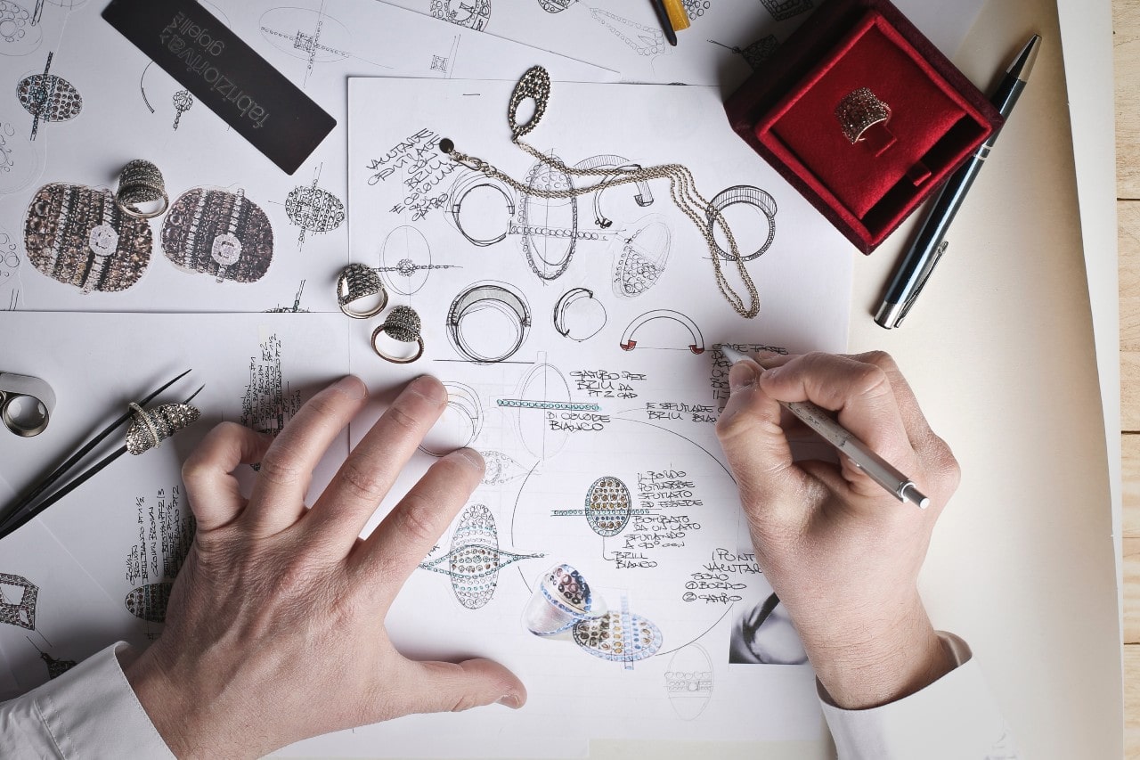 An overhead shot of a jeweller sketching jewelry designs.