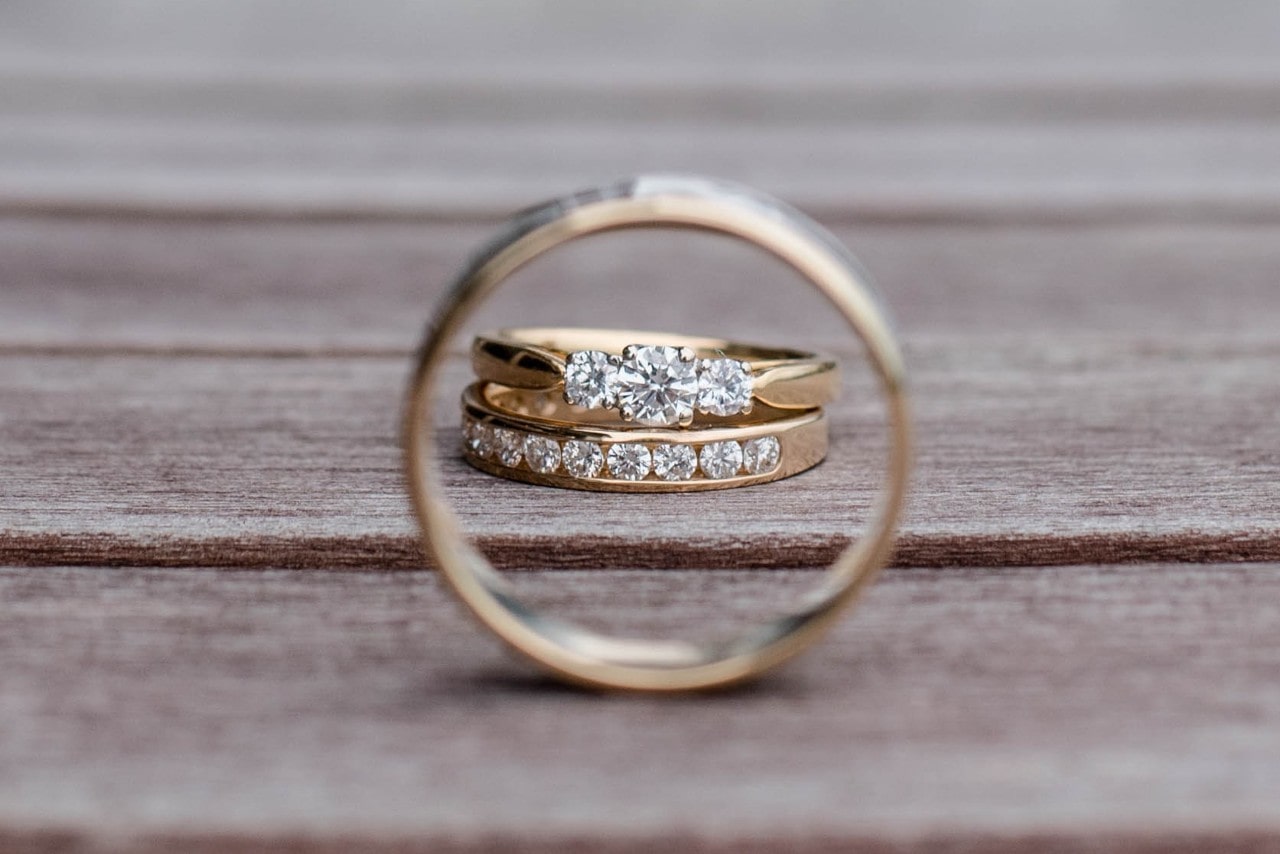 Two diamond wedding bands on a wooden surface, shot from inside the third ring.